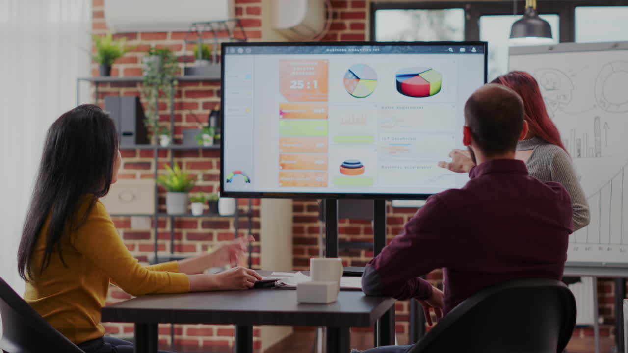 Business people looking at statistics presentation on screen