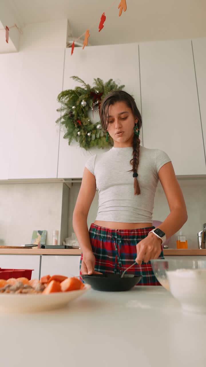 Donna che cucina in una cucina a tema natalizio