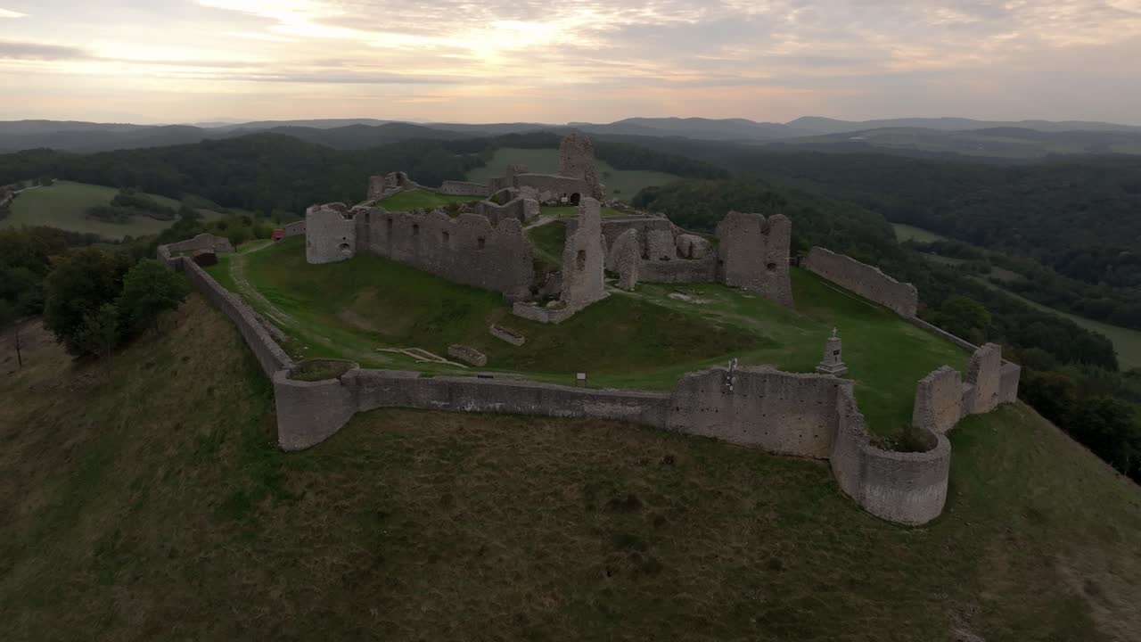 Drohnenaufnahmen von Burg Branc, eingebettet zwischen dichten Wäldern und offenen Feldern.