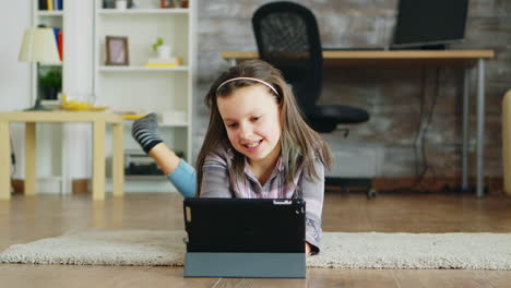 Cheerful-little-girl-with-braces-lying-on-the-floor-carpet