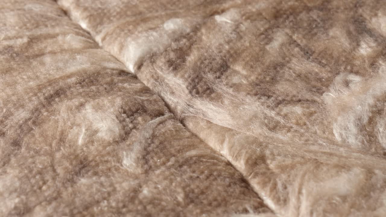 Clouse up view of mineral wool insulation being cut several times with a kinfe