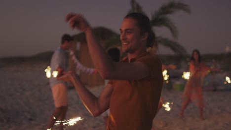 caucasian man playing with fire on the beach