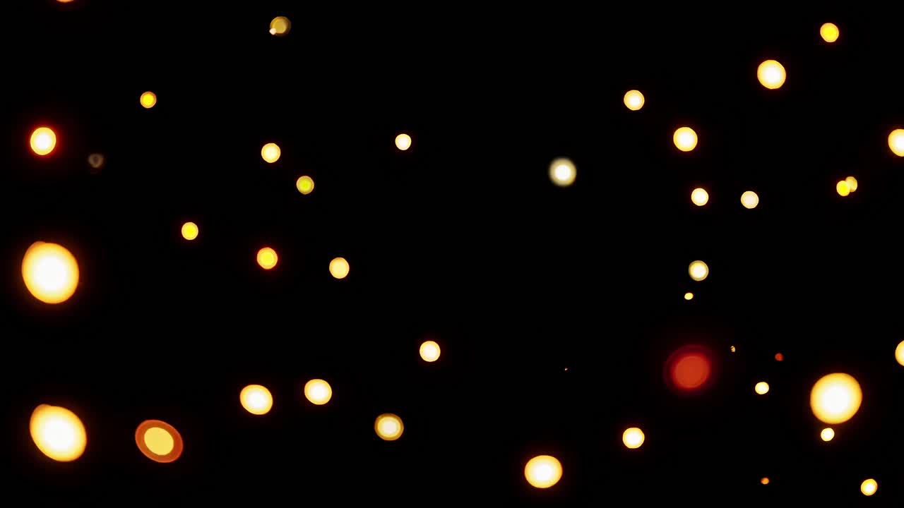 A video captures glowing bokeh lights against a dark background, with a straight-on camera angle
