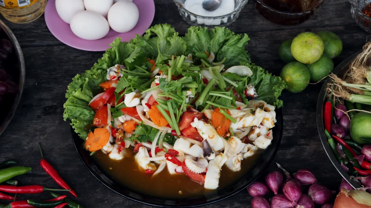 재료로 둘러싸인 테이블에 놓인 완성된 신선한 오징어 요리