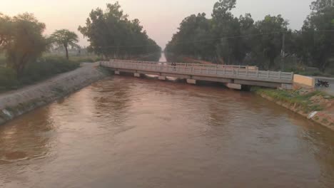 aerial view bridge over river during golden hour in karachi. dolly back