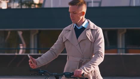 man with smartphone going near bicycle