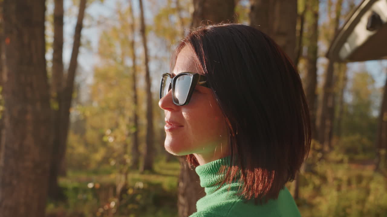 Donna caucasica con capelli corti si diletta in un'avventura all'aperto vibrante in autunno. Donna gioiosa intraprende una pittoresca escursione autunnale all'aperto sotto un cielo soleggiato con espressione allegra.