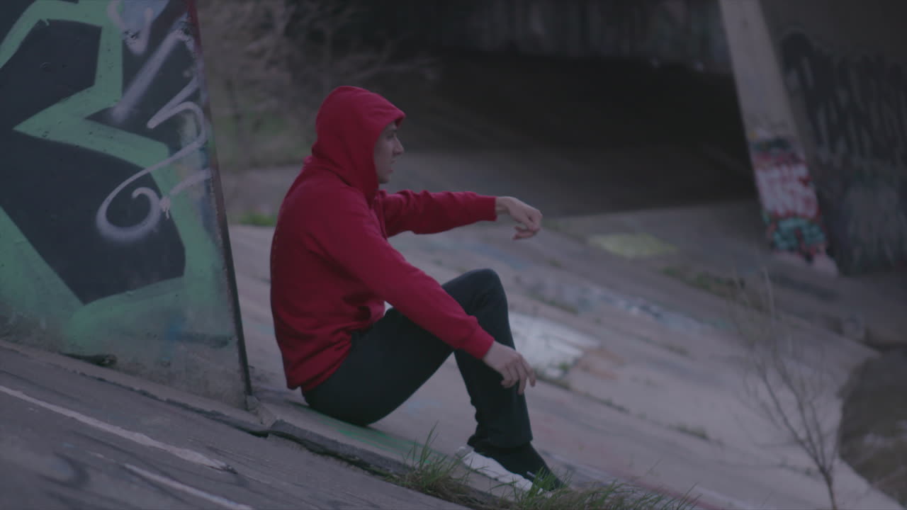 Women in white crop top. Man in sweater. Urban wear under highway by city river.