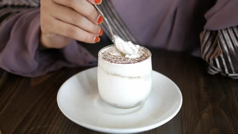 una mujer comiendo tiramisu.