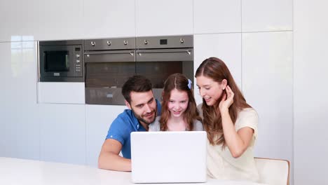 familia feliz con hija usando computadora portátil