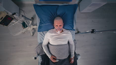 patient in hospital bed with oxygen mask