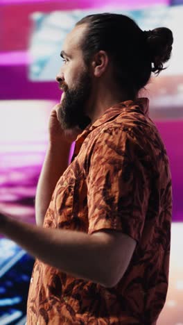 vertical video artistic person and dj answering phone call under vibrant neon lights