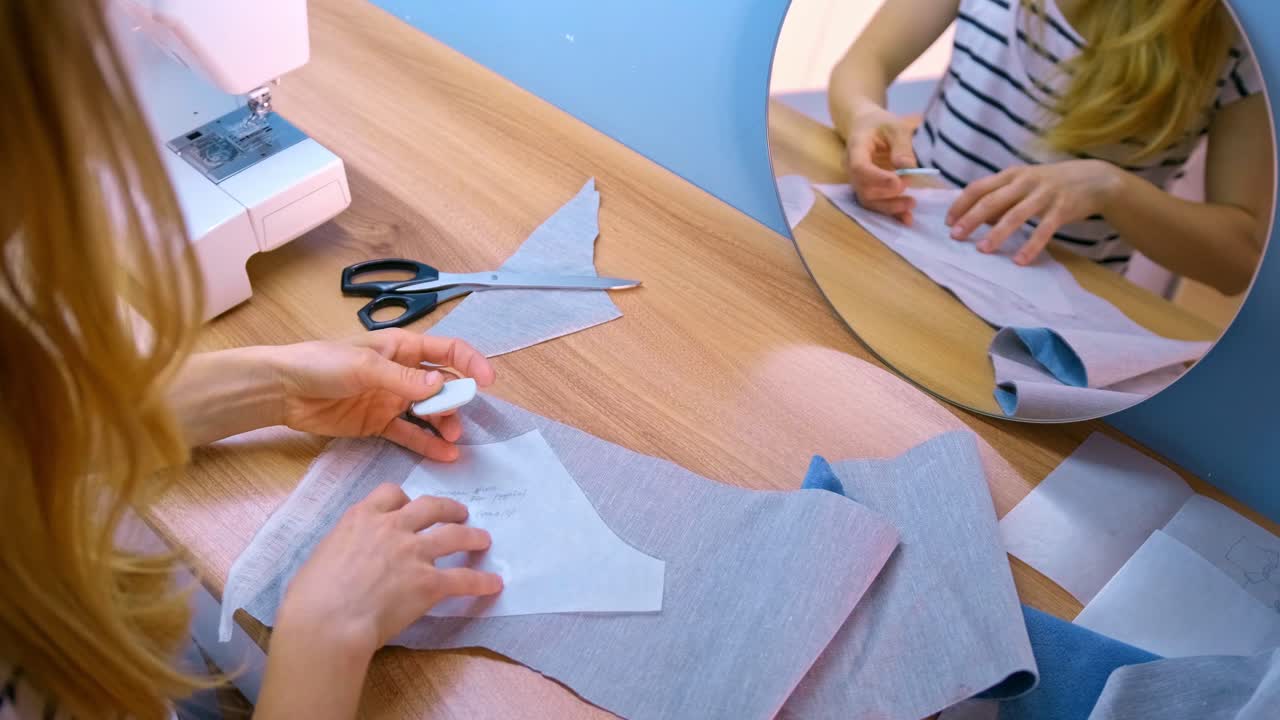 Crafting a Beautiful Garment: A Seamstress Engaged in Pattern Cutting and Fabric Preparation for Sewing on a Stylish Sewing Machine at a Cozy Workspace