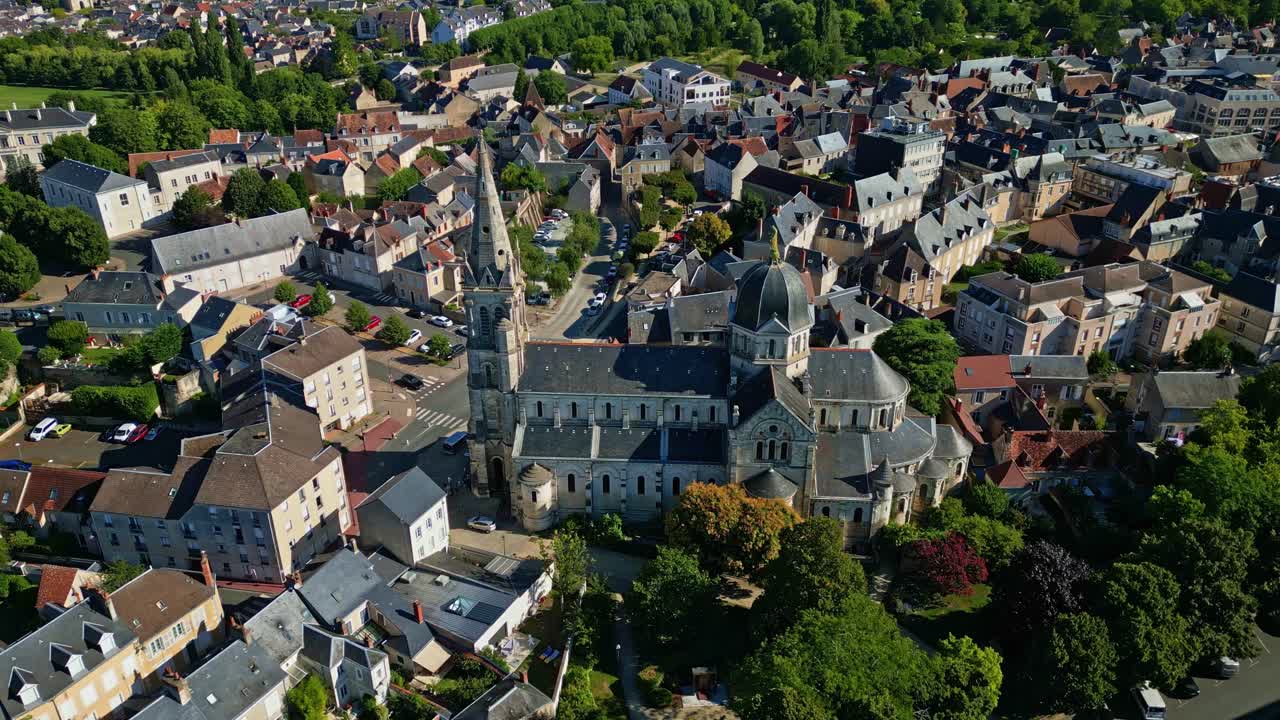 High aerial orbit of Notre-Dame de Châteauroux and nearby town in clear daylight conditions