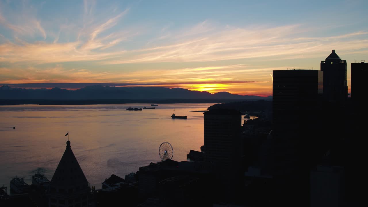 Aerial shot of the sun setting over the Olympic Mountains from Seattle's perspective, circa 2017.