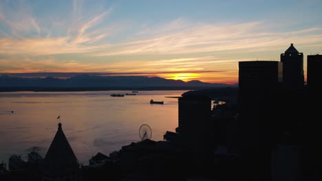 aerial shot of the sun setting over the olympic mountains from seattle's perspective, circa 2017.