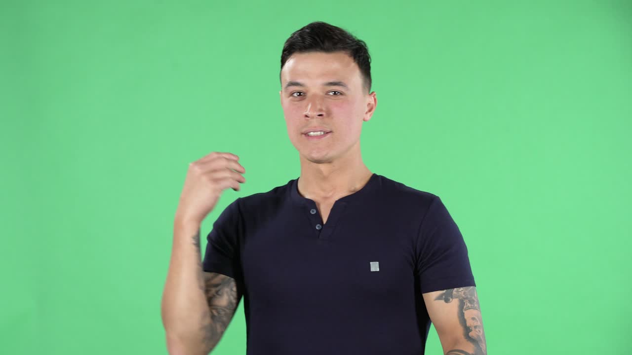 retrato de un joven guapo está esperando algo para pasar y morder su puño. pantalla verde