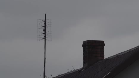 antena de televisión antigua en la parte superior del techo durante el pueblo de lluvia