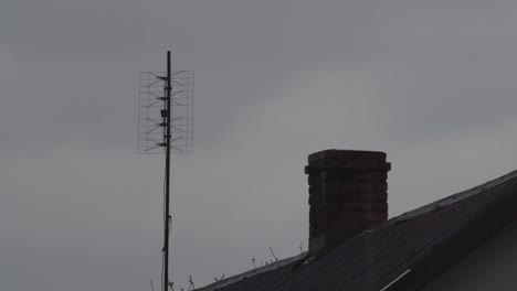 old tv antenna on the top of the roof during rain village