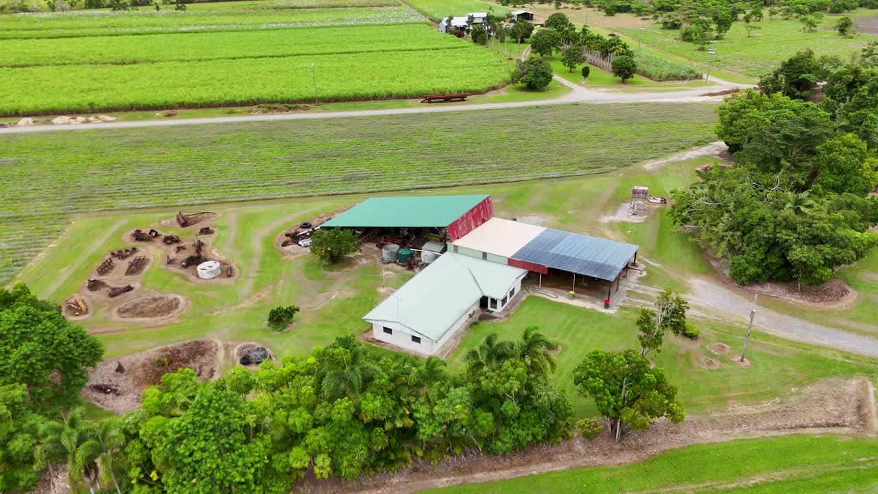 Drone footage captures a rural farm with sugarcane fields in Port Douglas, Queensland, under bright daylight