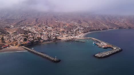 aerial establishing frontal overview of cedros island’s fishing harbor, turquoise waters, and docked fishing boats