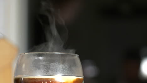 close up slow motion shot of cream added to smoking hot coffee drink