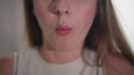 close up of young woman in sleeveless gown eating meat with chopsticks, mouth open about to take bite, soft lighting highlighting facial features, natural indoor setting