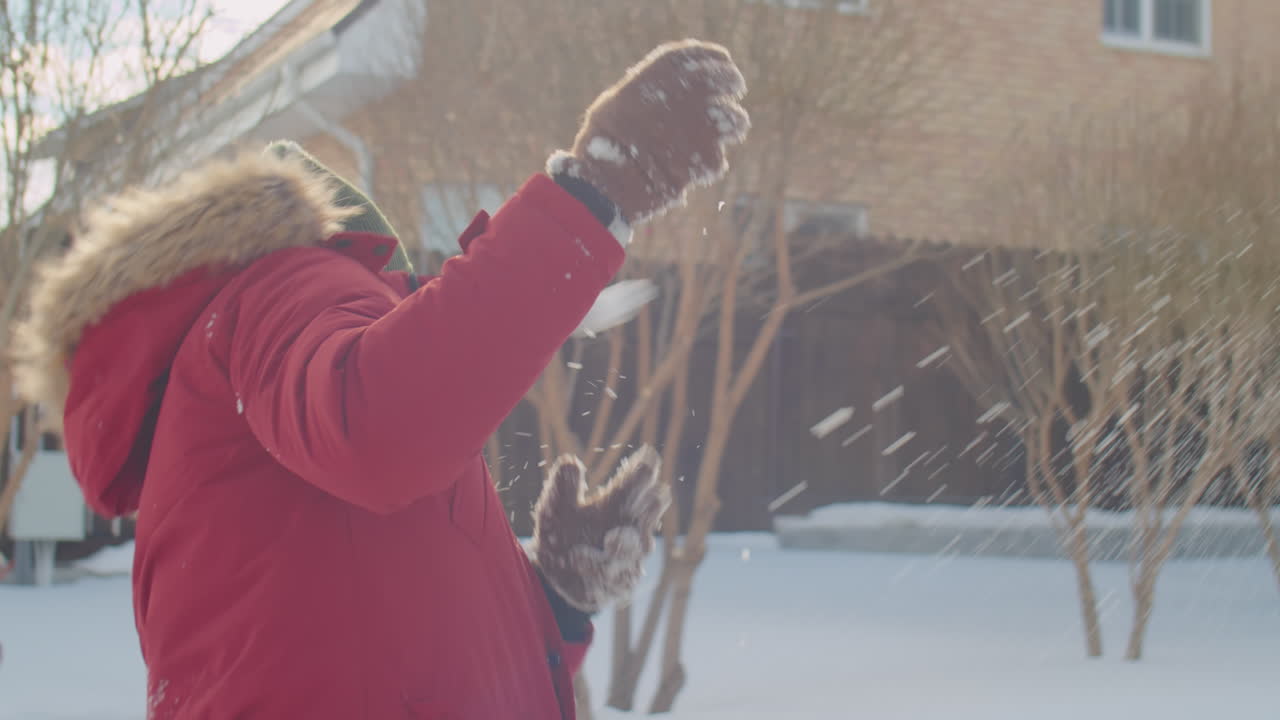 Happy Parents and Kid Playing Snowballs Outside on Winter Day