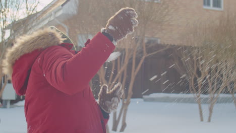 happy parents and kid playing snowballs outside on winter day