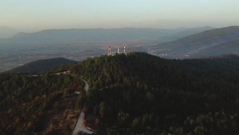 vista aérea sobre torres de telecomunicaciones en un bosque de pinos al atardecer
