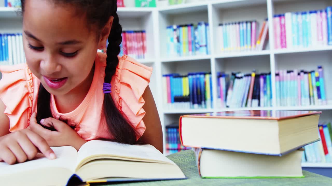 estudiante leyendo un libro en la biblioteca de la escuela