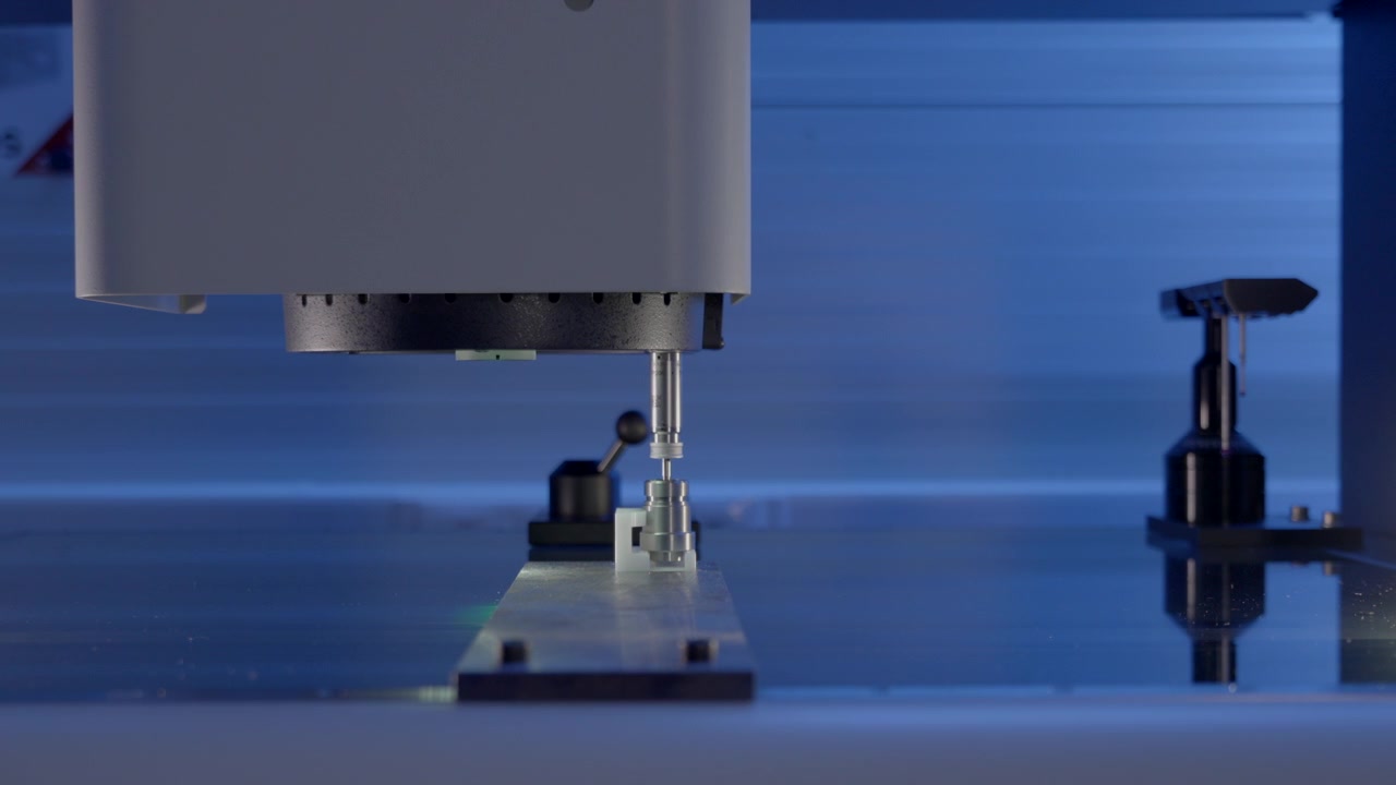 Macchina di metrologia ottica che analizza le dimensioni di un pezzo fabbricato con CNC di precisione con illuminazione di ispezione.