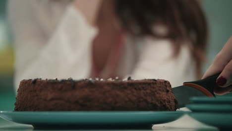 mujer cortando a mano el pastel de cumpleaños con un cuchillo. postre de la fiesta de cumpleaños