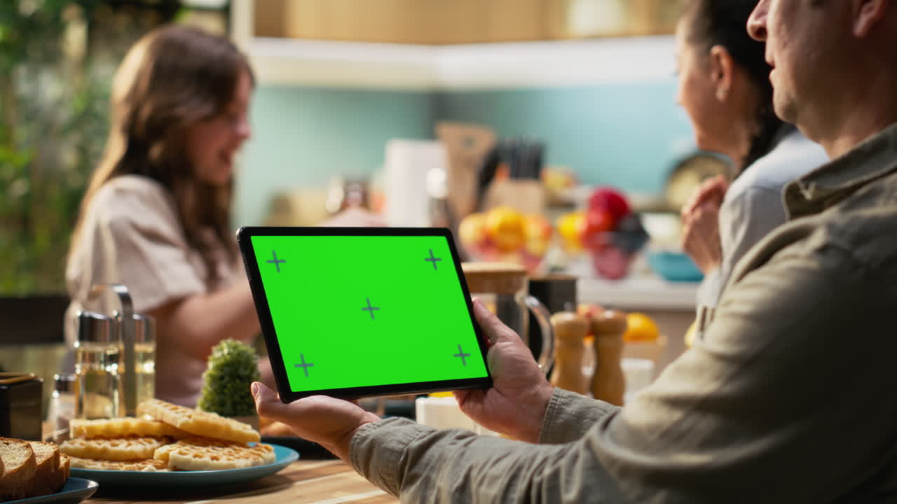 Mockup screen on tablet with father gathered for breakfast with his family