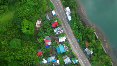 Orbitando-Sobre-Viviendas-Junto-A-La-Carretera-Pavimentada-Cerca-De-La-Orilla-Del-Río-En-Catanduanes,-Filipinas