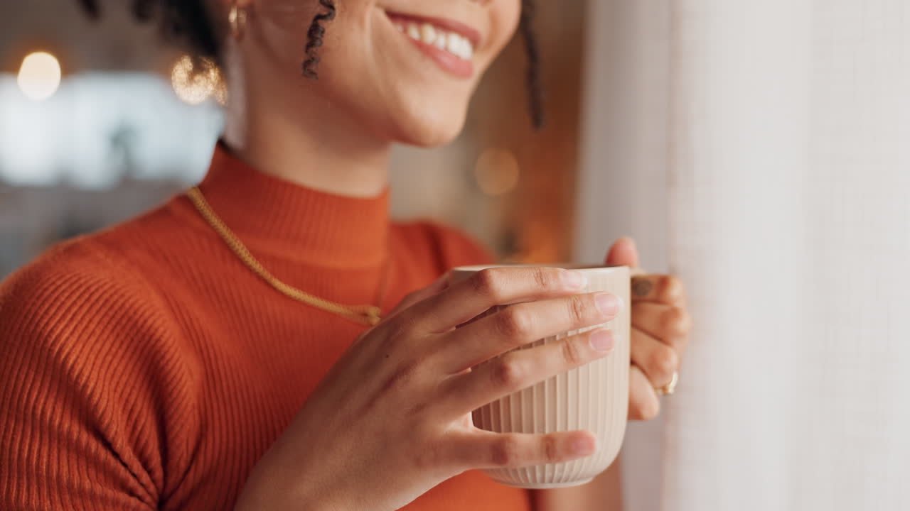 mujer disfrutando de una bebida caliente junto a la ventana