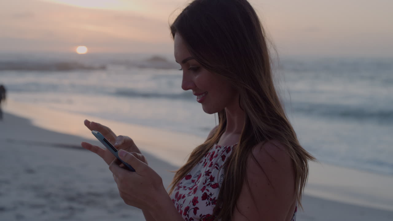 ritratto di una giovane donna caucasica che usa uno smartphone per scattare una foto su una bellissima spiaggia tranquilla al tramonto stile di vita di viaggio slow motion