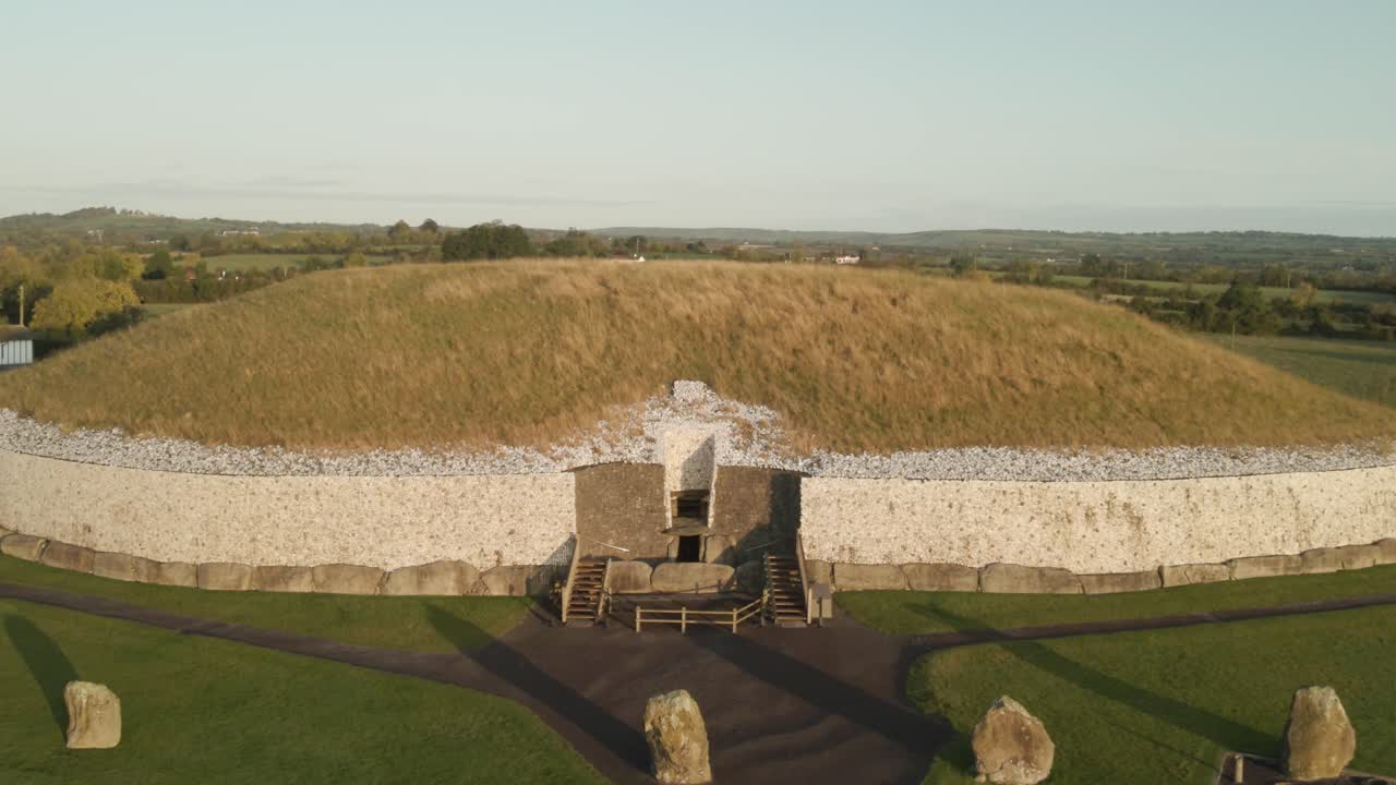 Entrance Of Newgrange Monument At Sunrise In County Meath, Ireland. - aerial pullback shot