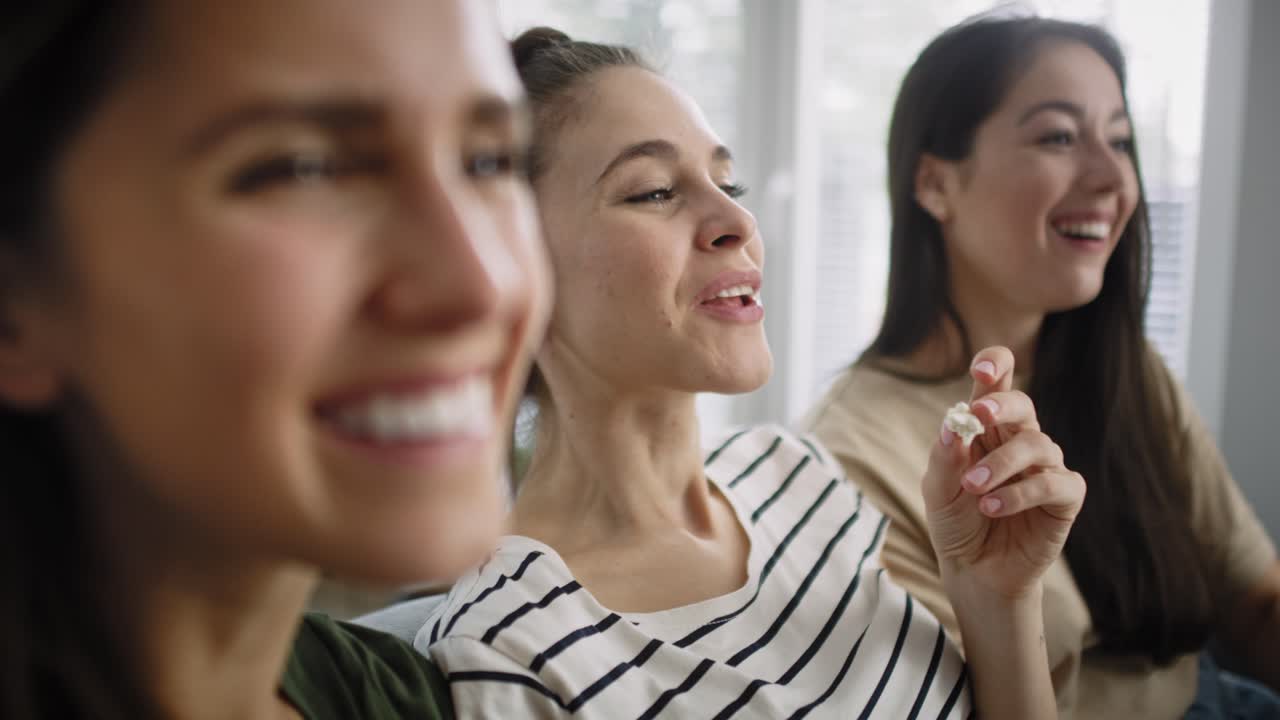 집에서 텔레비전을 보는 행복한 여성들의 비디오를 확대합니다.