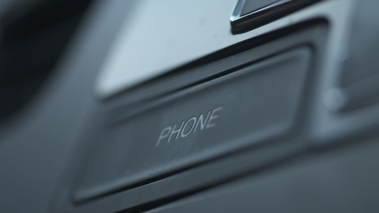 dedo presionando el botón bluetooth del teléfono en el tablero de un auto