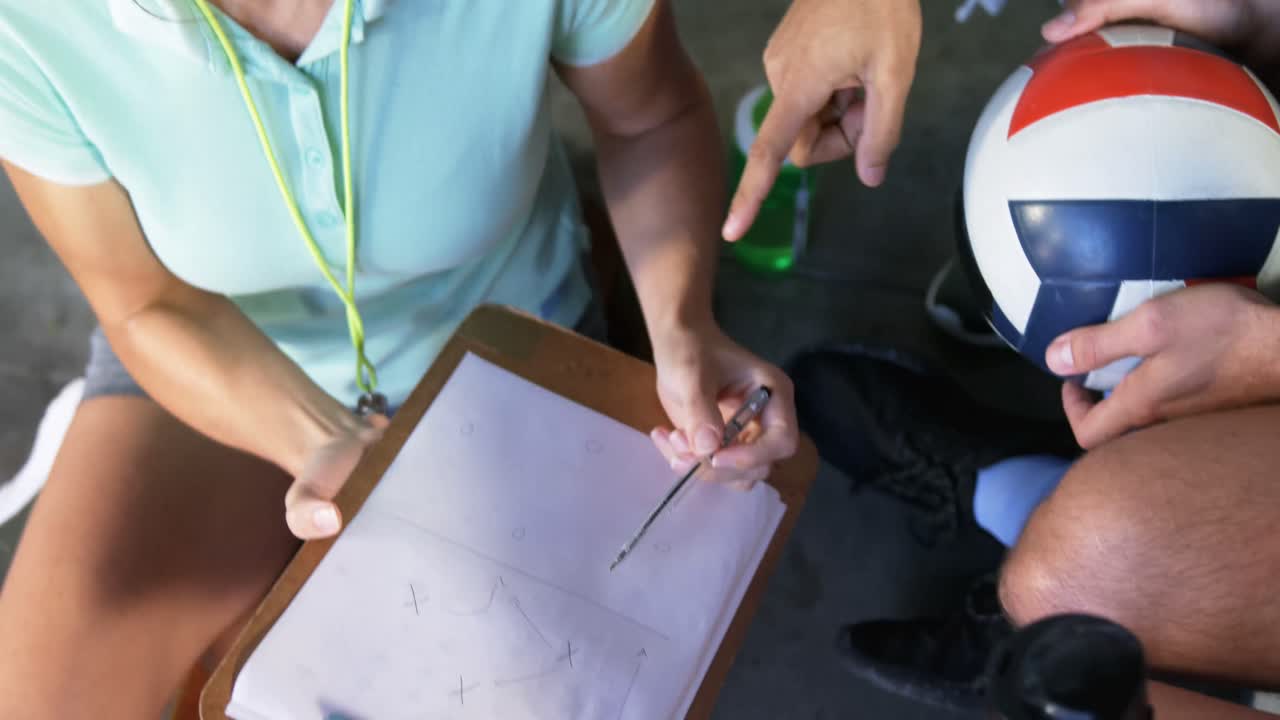 entrenador de voleibol ayudando a los jugadores en el clipboard 4k