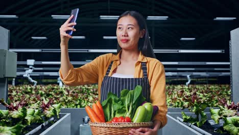 mujer agricultora tomando una selfie con verduras frescas en un invernadero