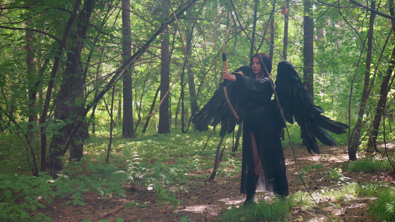 Fallen black fairy goddess with large dark wings draws bow in lush forest, aiming arrow through golden sunlight and swirling tree dust, embodying strength, mystery, and ethereal power
