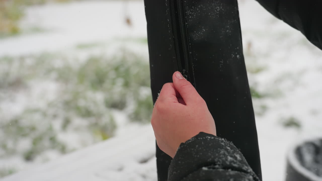 눈이 많이 내리는 겨울날, 부드러운 눈송이가 떨어지고 눈으로 인 공원의 자연적인 배경이 흐릿한 야외에서 손을 고 기타 을 열고 있습니다.