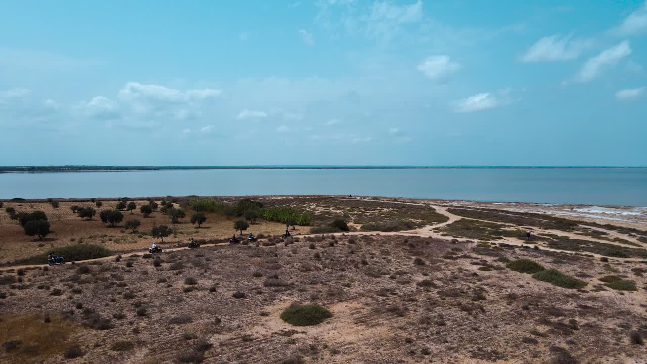 ATV Riders on a Dirt Track by a Salt Lake