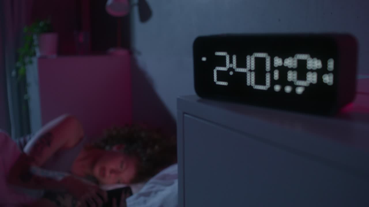 밤에 침대에 누워서 전화를 보고 있는 여자