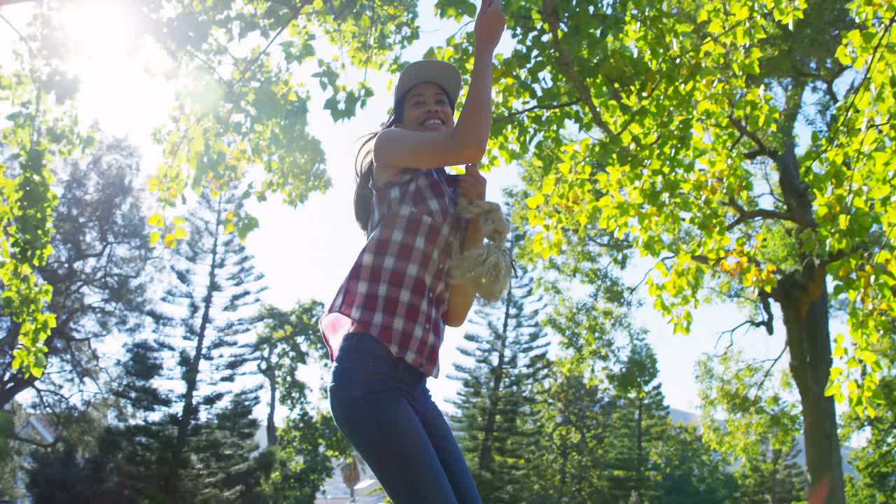 mujer jugando con cuerda colgante en el parque 4k