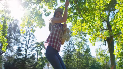 woman playing with hanging rope in park 4k