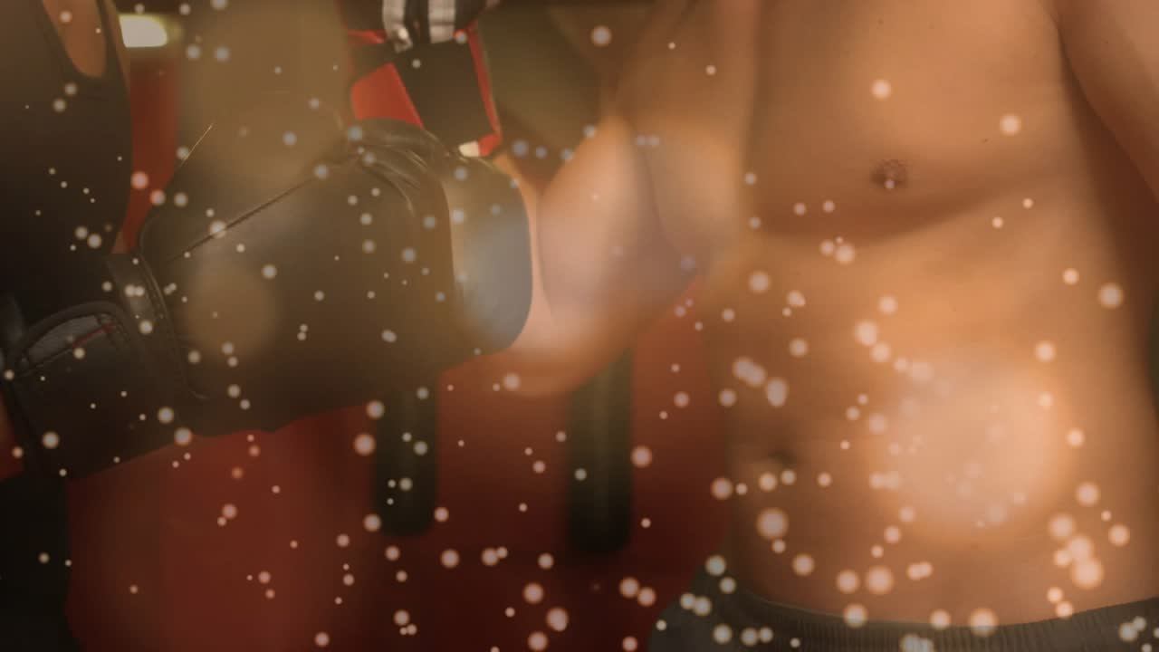 Two men sparring in fitness, tank partner initiating light black-glove taps, bokeh showing impact