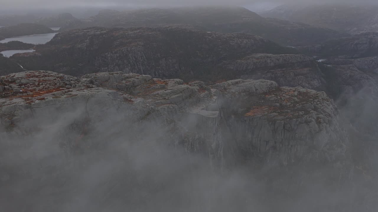 Vista aérea del sendero de Preikestolen rodeado de nubes durante la hora dorada.